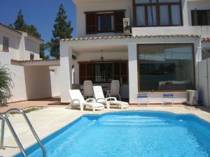 una piscina frente a una casa en Villas Aloha Valdelagrana, en El Puerto de Santa María