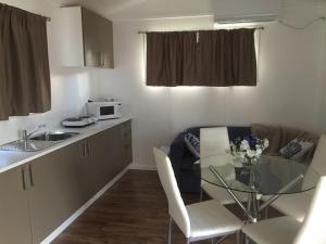 a small kitchen with a glass table in a room at Oakridge Motel Tourist Park in Oakey