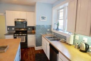 a kitchen with white cabinets and a stove top oven at The Greenleaf House in Chicago