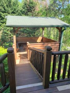 a wooden deck with a gazebo with a roof at Paw Prints Mountain View Cabin in Sevierville
