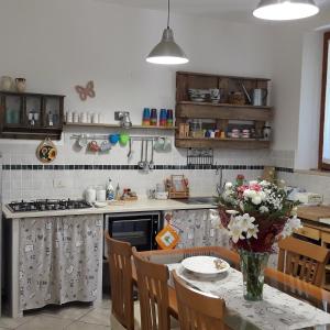 eine Küche mit einem Tisch und einer Blumenvase darauf in der Unterkunft La casa di Eva in Castel Viscardo