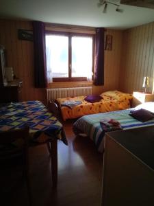 ein Hotelzimmer mit 2 Betten und einem Fenster in der Unterkunft Chambre d'hôtes Petit Martel in Les Ponts-de-Martel