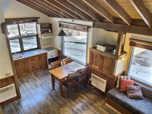 a kitchen and dining room with a table and a couch at Merrigang Chalet, Dinner Plain in Dinner Plain