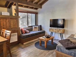 a living room with a couch and a tv at Merrigang Chalet, Dinner Plain in Dinner Plain