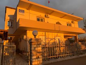uma casa amarela com uma cerca em frente em Ksamil Harmony Studios em Ksamil