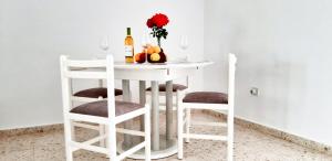 einem weißen Tisch mit zwei Stühlen und einer Flasche Wein in der Unterkunft CORAL BAY suite Cyprus in Coral Bay