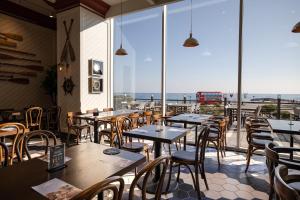 a restaurant with tables and chairs and a view of the ocean at Kensington Resort Seorak Beach in Sokcho