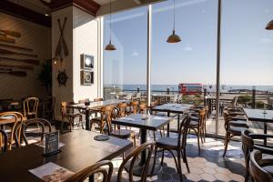 a restaurant with tables and chairs and a view of the ocean at Kensington Resort Seorak Beach in Sokcho +29 photos