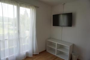 a white room with a television and a window at good bed wynau in Wynau