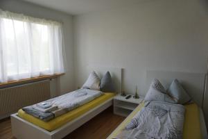 a bedroom with two beds and a window at good bed wynau in Wynau
