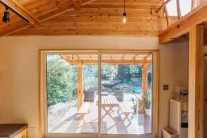 a house with a glass door leading to a patio at PACIFICO SURF HOUSE - Mountain in Shishikui