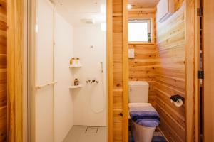a small bathroom with a toilet and a shower at PACIFICO SURF HOUSE - Mountain in Shishikui