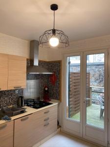 una cucina con piano cottura forno superiore accanto a una finestra di appartement vivier 4 personnes tout confort a Boulogne-sur-Mer