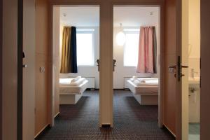 a room with two beds and two windows at Maverick Budapest Soho in Budapest