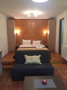 a bedroom with a large bed with a blue couch at Kalmia Studio in Sinaia