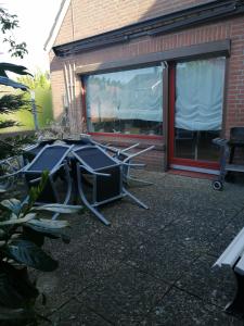 TV y sillas situadas fuera de un edificio en Wohnung Lemkenhafen, en Fehmarn