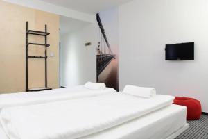 a room with three beds and a tv and a bridge at Maverick Budapest Soho in Budapest