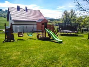a yard with a playground with a slide at Beskid House Kurów in Kurów