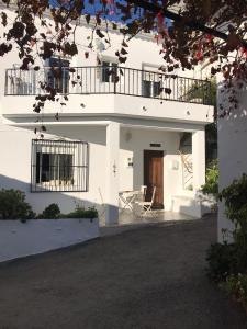a white house with a balcony and a chair at Casa Cometa in Altea la Vieja