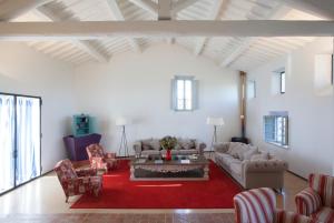 salon z kanapami i czerwonym dywanem w obiekcie Agriturismo Borgo Personatina w mieście Sovicille