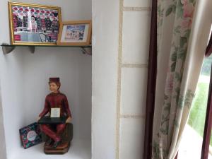 a doll sitting on a shelf in a room at CoTTAGE LA VILLA BOLERO in Saint-Cyr-sur-Loire