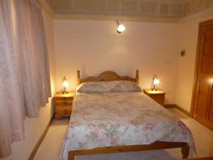a bedroom with a bed and two lamps on tables at San Antonio Guesthouse in Xlendi