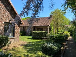 a brick house with a yard with bushes at Les Cottages d'Orient Gite Boutique in Mesnil-Saint-Père