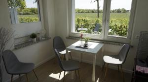 uma mesa branca e cadeiras num quarto com janelas em Ferienwohnung Wiesenblick nahe Region Celle und Hannover em Buchholz Aller