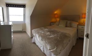 a bedroom with a large bed and a window at South Beach Apartment in Ardrossan