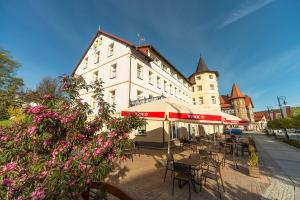 ein Gebäude mit Tischen und Stühlen davor in der Unterkunft Dobrzyński Resort Topaz in Świeradów-Zdrój