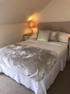 a bedroom with a bed with a silver blanket on it at South Beach Apartment in Ardrossan
