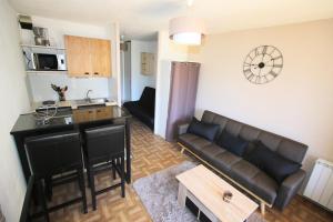 cocina y sala de estar con sofá y mesa en Mas de Blais appartement Chaleureux à 5 minutes des pistes en Briançon