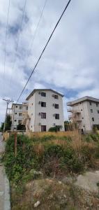 two white buildings in a field next to a street at Roan Apartments in Velipojë