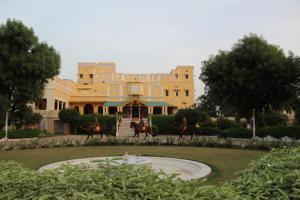 Dos caballos corren delante de un edificio. en Roop Niwas Kothi, Near Mandawa, en Nawalgarh