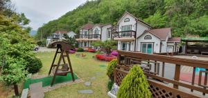 une maison avec une cour dotée d'une clôture en bois dans l'établissement Forest of Color Pension, à Hongcheon