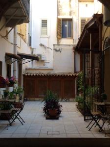 an empty courtyard with chairs and plants in a building at Sylvia Home Apt and Rooms with kitchenette in Trapani
