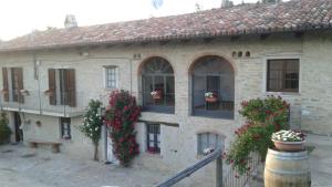 a building with flowers on the windows and a barrel at Cà Tinola in Mango