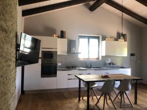 a kitchen with white cabinets and a table with chairs at Cà Tinola in Mango +35 photos