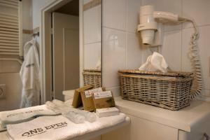 een badkamer met een wastafel, een spiegel en handdoeken bij Aparthotel Ons Epen in Epen