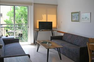 a living room with a couch and a tv at Chrielka Hotel in Limassol