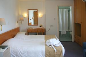 a hotel room with a bed with towels on it at Chrielka Hotel in Limassol