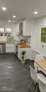 a kitchen with white cabinets and a table with a plant at Casa de la Abuela en el Camino de Santiago a Finiesterre in Negreira