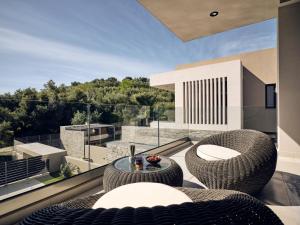 a patio with two chairs and a table on a balcony at Aguacate Ioni in Tsilivi