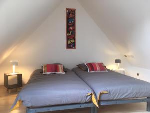 sypialnia z 2 łóżkami i 2 lampami na poddaszu w obiekcie LA CHAMADE w mieście Carolles