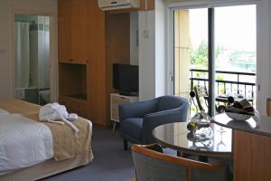 a hotel room with a bed and a table and a television at Chrielka Hotel in Limassol