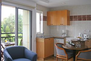 a kitchen with a table and chairs and a kitchen with a balcony at Chrielka Hotel in Limassol