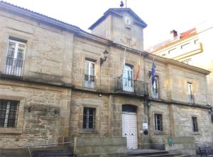 an old stone building with a clock tower on top at Casa de la Abuela en el Camino de Santiago a Finiesterre in Negreira