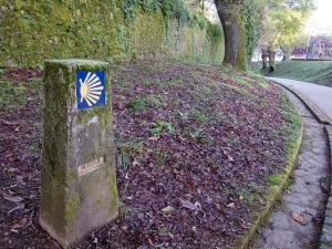 a stone sign on the side of a road at Casa de la Abuela en el Camino de Santiago a Finiesterre in Negreira