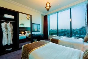 a hotel room with two beds and a large window at Platinum Seventy in Jeddah