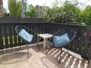 two chairs with blue pillows sitting next to a table at Olive Hostel in Gdańsk